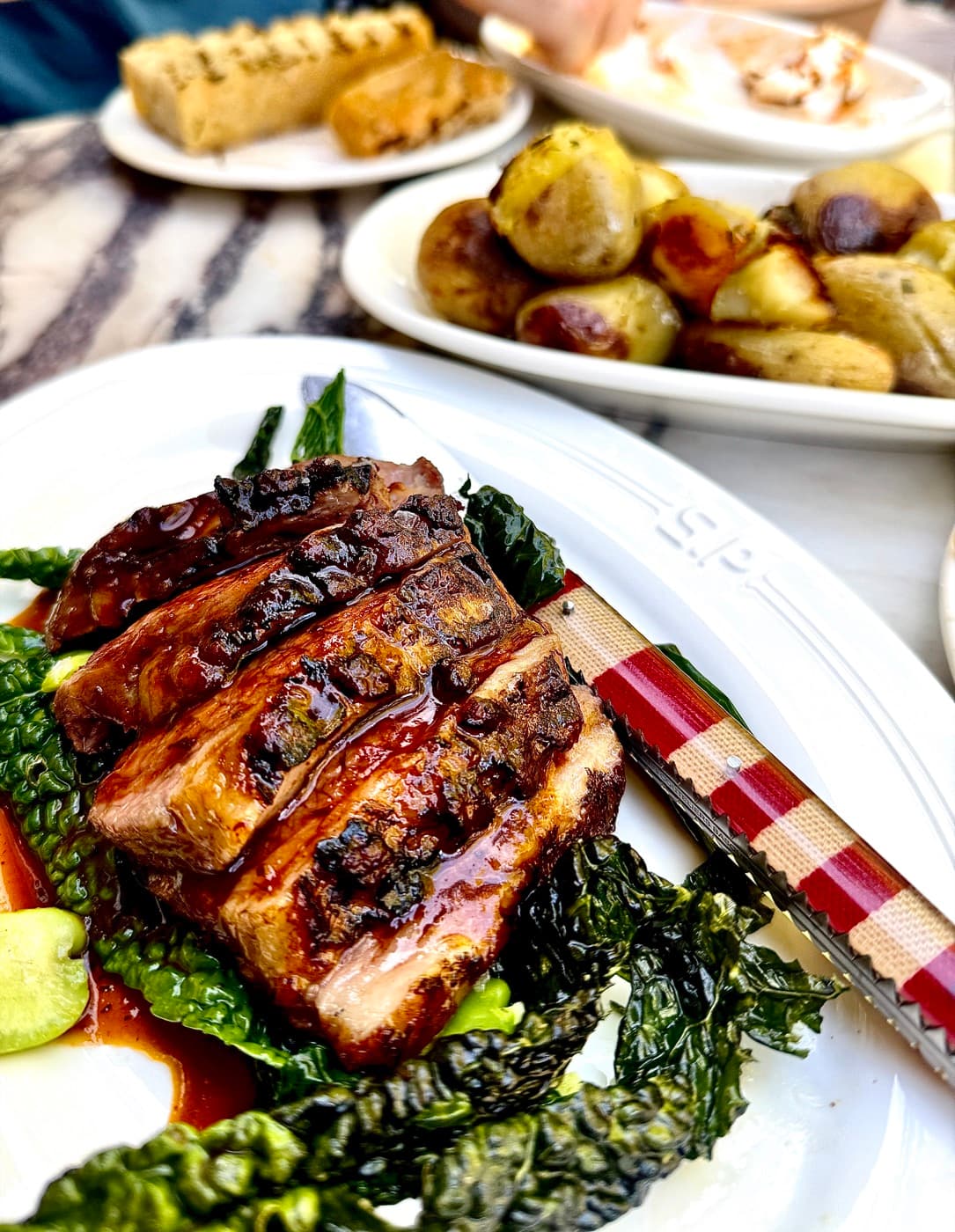 Milk-fed lamb shoulder on cavolo nero, with smoked potatoes behind