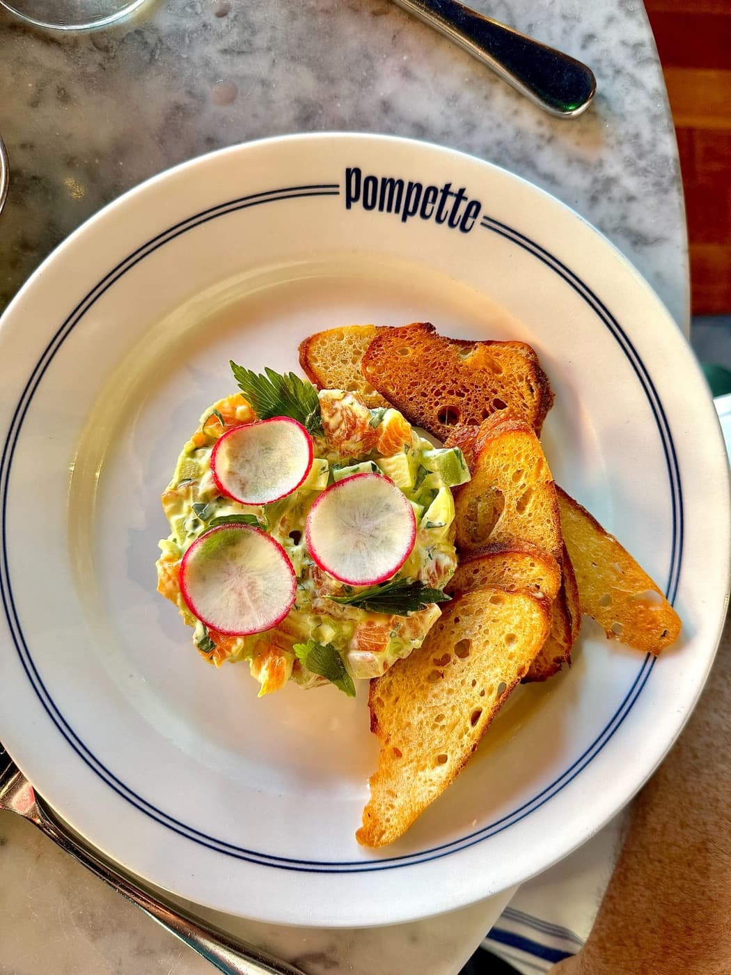 Chalk stream trout tartare topped with sliced radish, served with toasts
