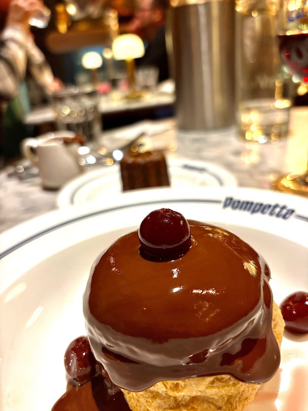 A glossy chocolate-glazed dessert topped with cherries