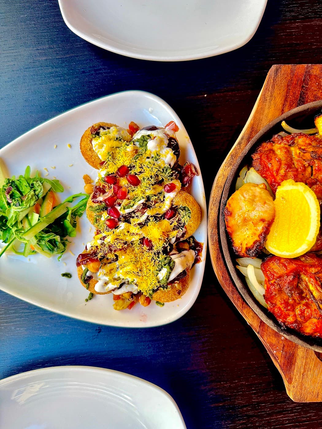 Gol gappa chaat and a tandoori sizzler on a wooden board at Tempering