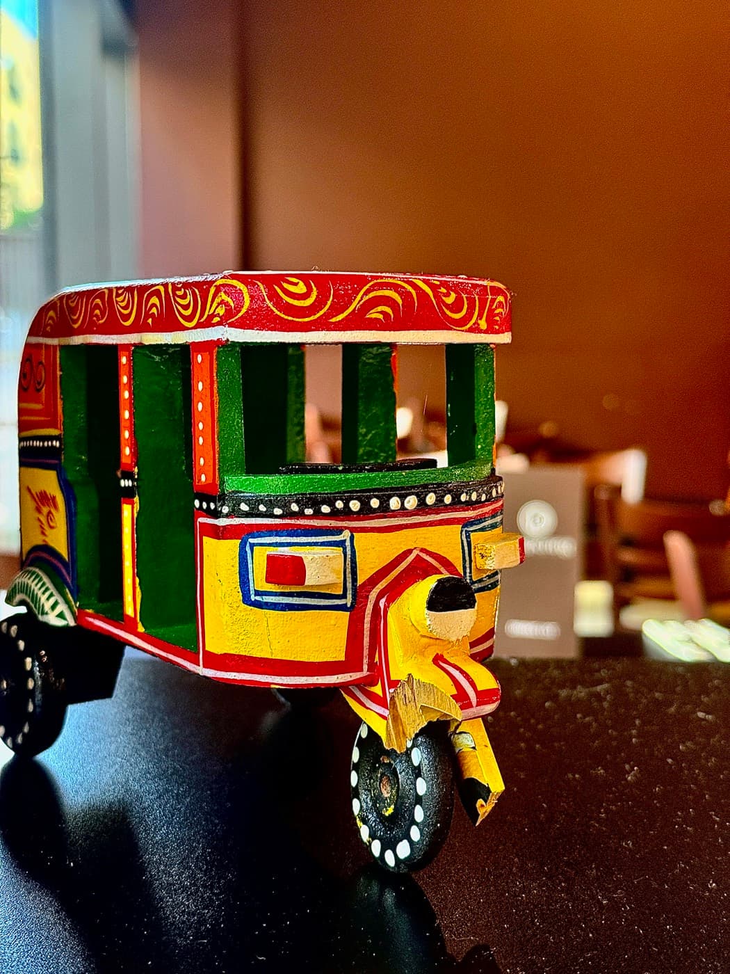 A hand-painted model auto-rickshaw on the table at Tempering